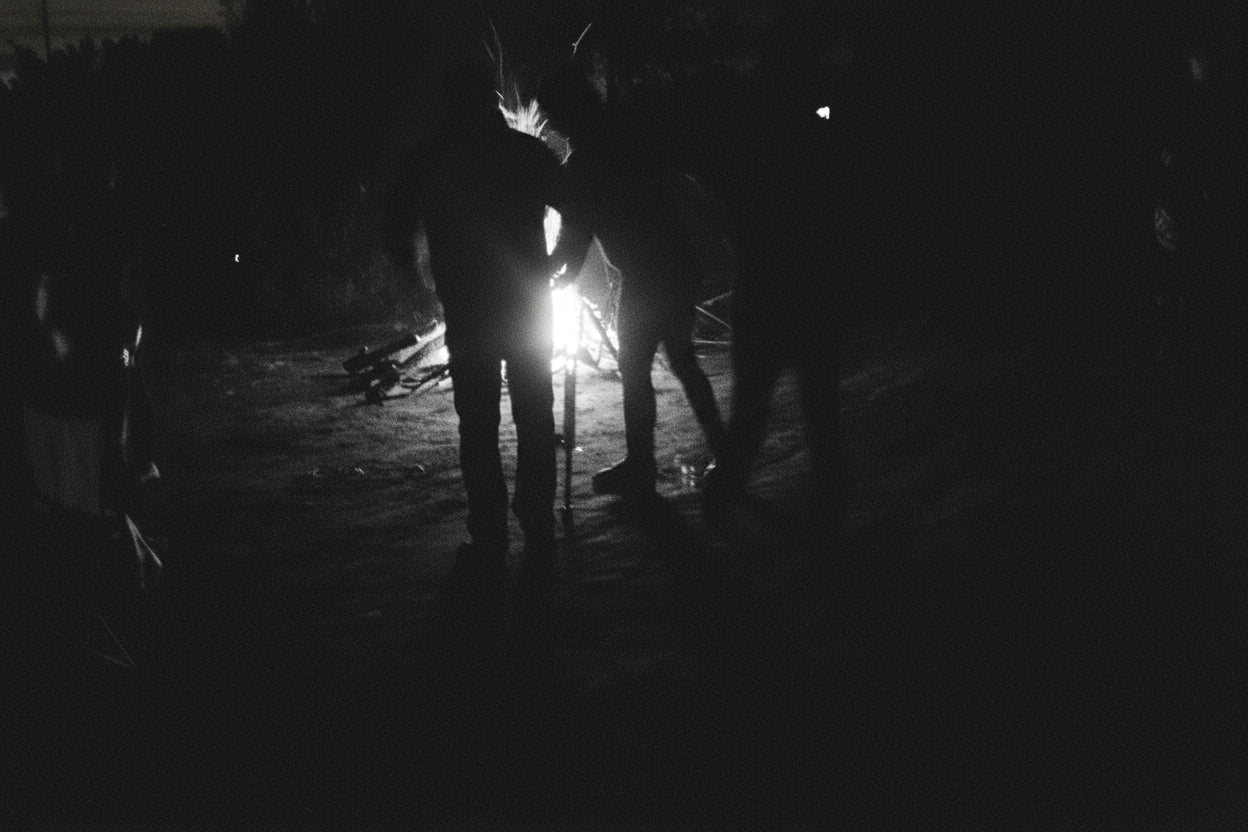 image en noir et blanc d'un feu de camp avec des personnes autour